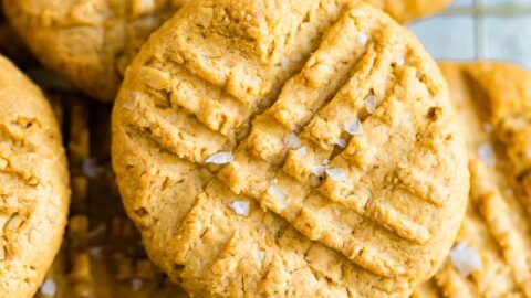 Peanut butter cookies sprinkled with sea salt on a cooling rack.