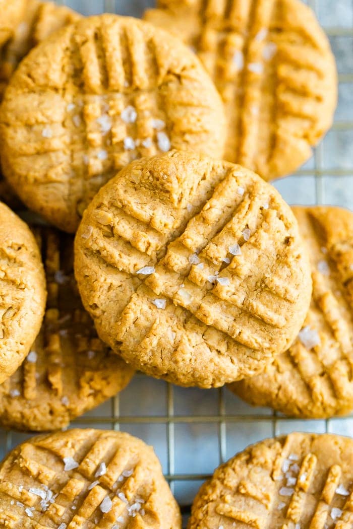 Peanut butter cookies sprinkled with sea salt on a cooling rack.