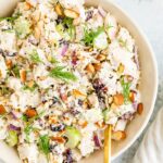 Bowl full of turkey salad topped with fresh dill and chopped almonds.