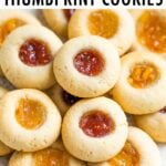 Close up photo of thumbprint cookies with raspberry and orange jams.