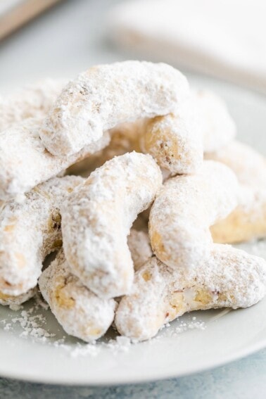Pile of gluten-free almond flour crescent cookies on a plate.