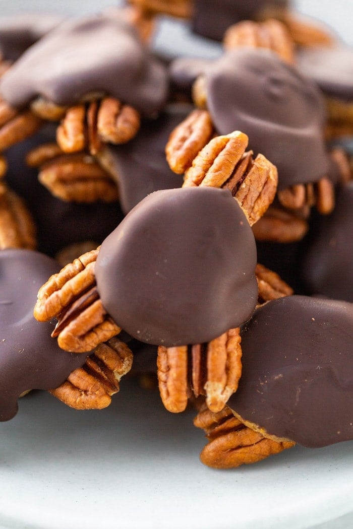Close up photo of homemade turtle candies made with pecans, date caramel and chocolate.