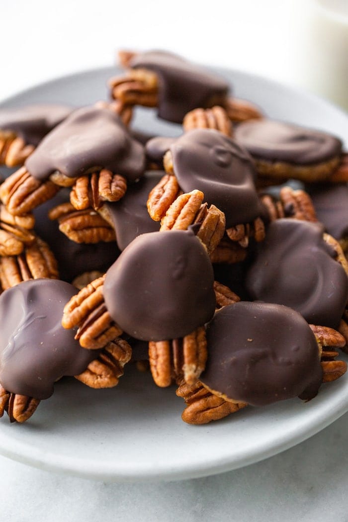 Chocolate pecan turtle candies on a plate.