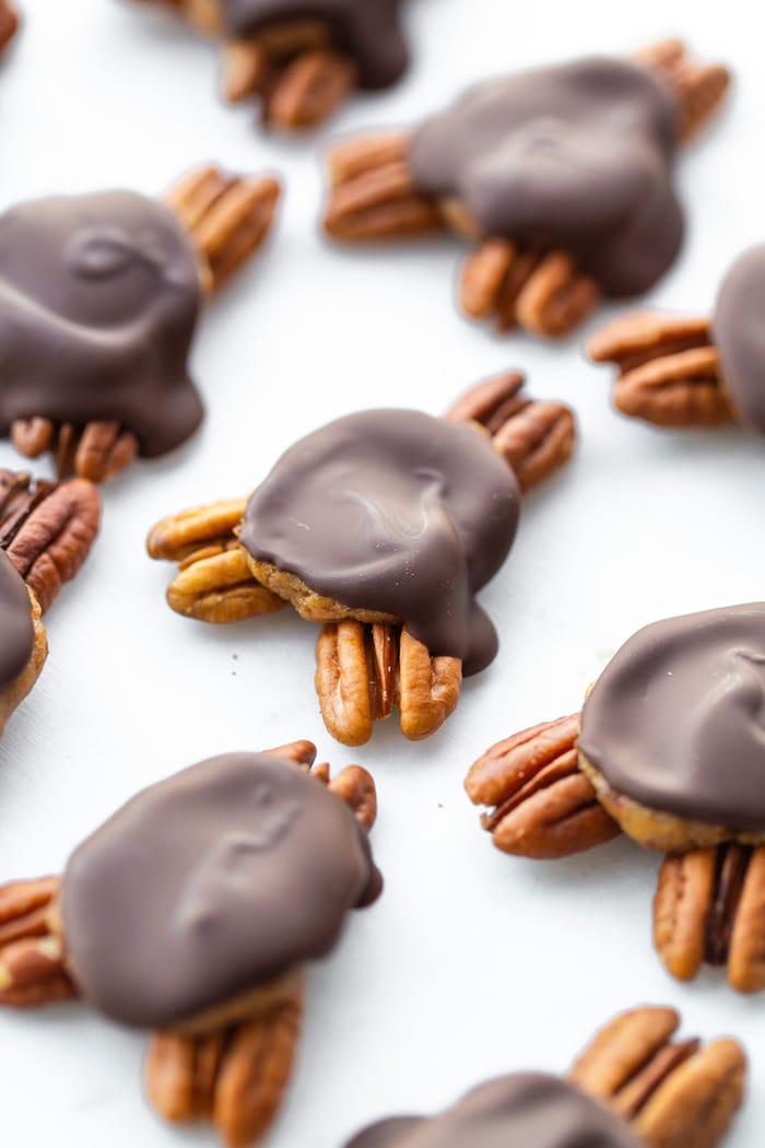 Homemade chocolate turtles on a white table.