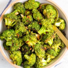 Bowl with roasted broccoli topped with red pepper flakes.