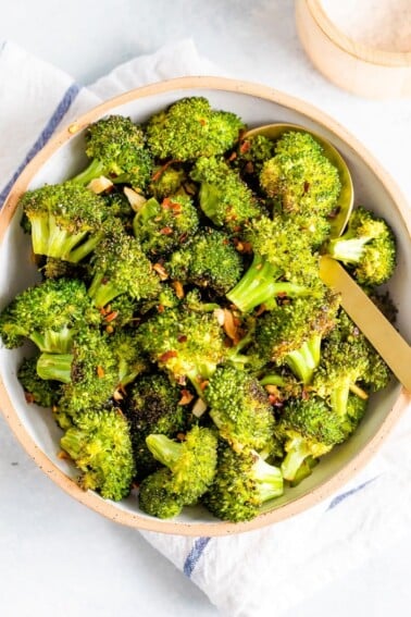 Bowl with roasted broccoli topped with red pepper flakes.