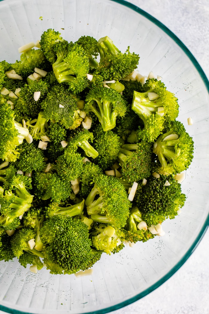 Mixing bowl with broccoli and chopped garlic,