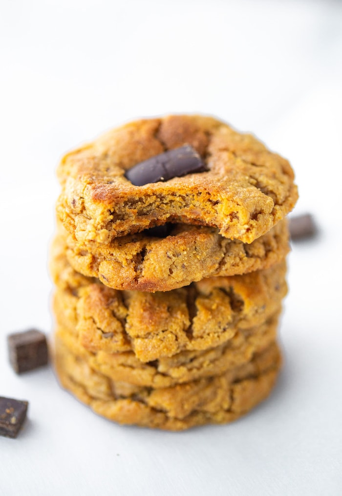 Stack of peanut butter blossom cookies. The top cookie has a bite taken out of it.