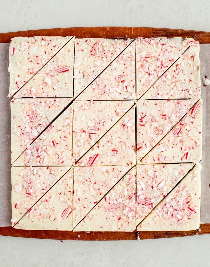 Peppermint bark on a cutting board cut into trianges.