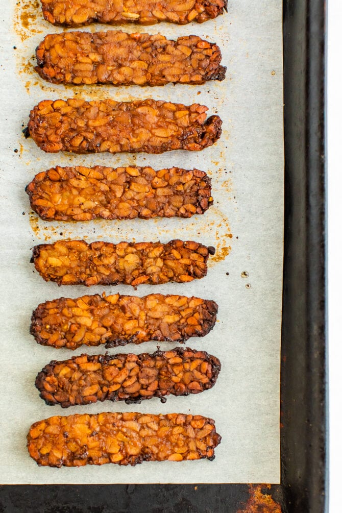 Baked tempeh bacon on a sheet pan.