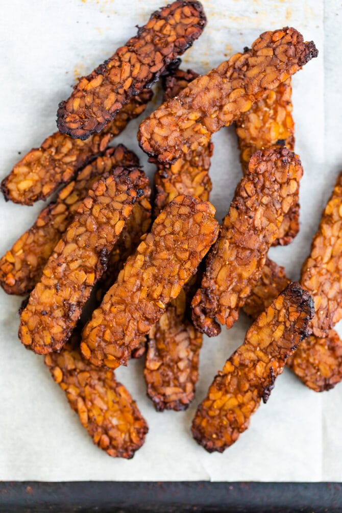 Crispy tempeh bacon on parchment paper.