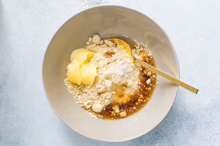 Ingredients for almond flour thumbprint cookies in a mixing bowl.