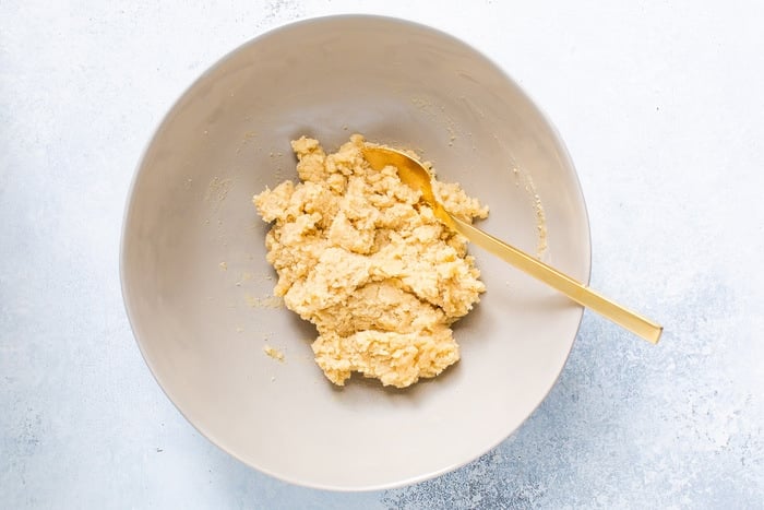 Mixed dough for almond flour thumbprint cookies in mixing bowl.