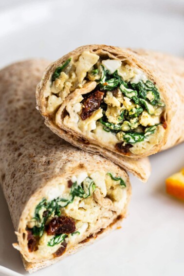 Two halves of an egg breakfast wrap on a plate.