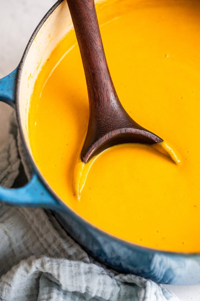 Wood ladle in a dutch oven of butternut squash soup.