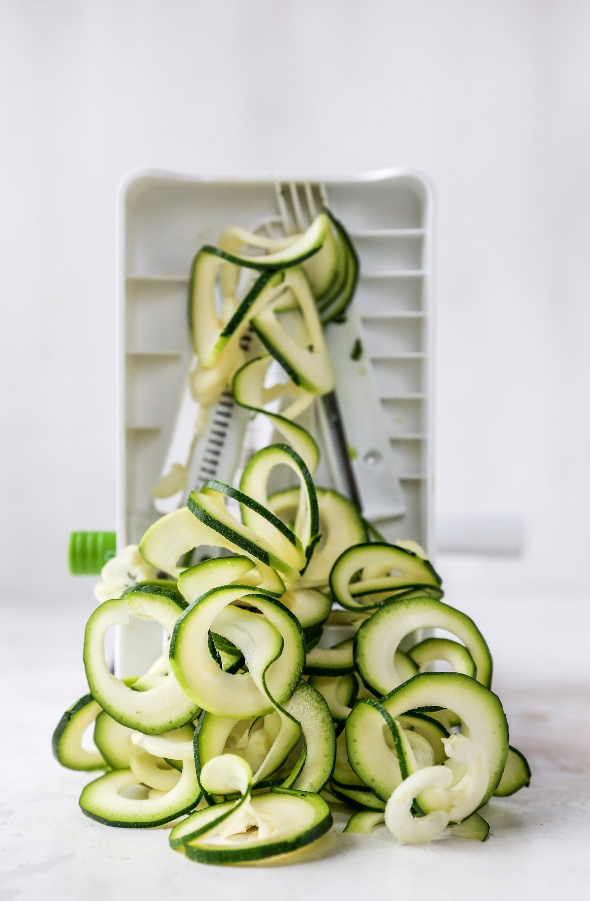 Zucchini noddles being made with a spiralizer.
