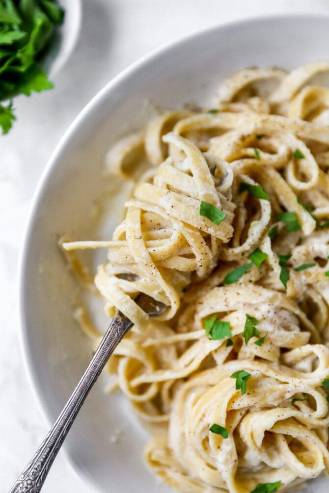 Fork twirling a bite of linguine alfredo.