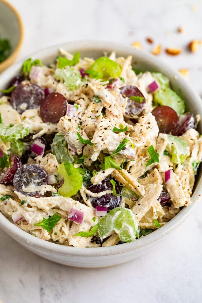 Bowl of chicken salad made with celery and grapes.