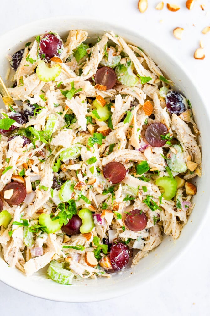 Bowl of chicken salad made with celery and grapes.