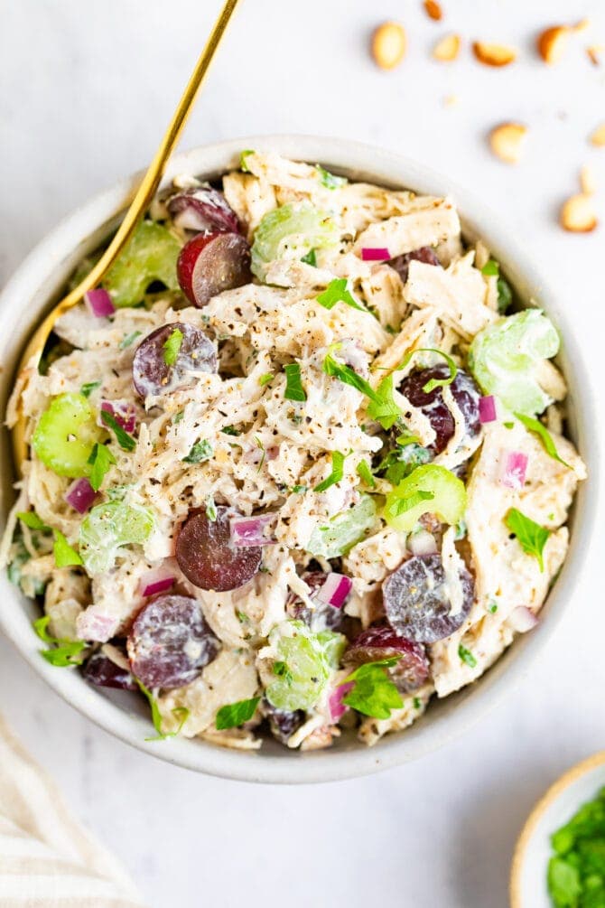 Bowl of chicken salad made with celery and grapes.