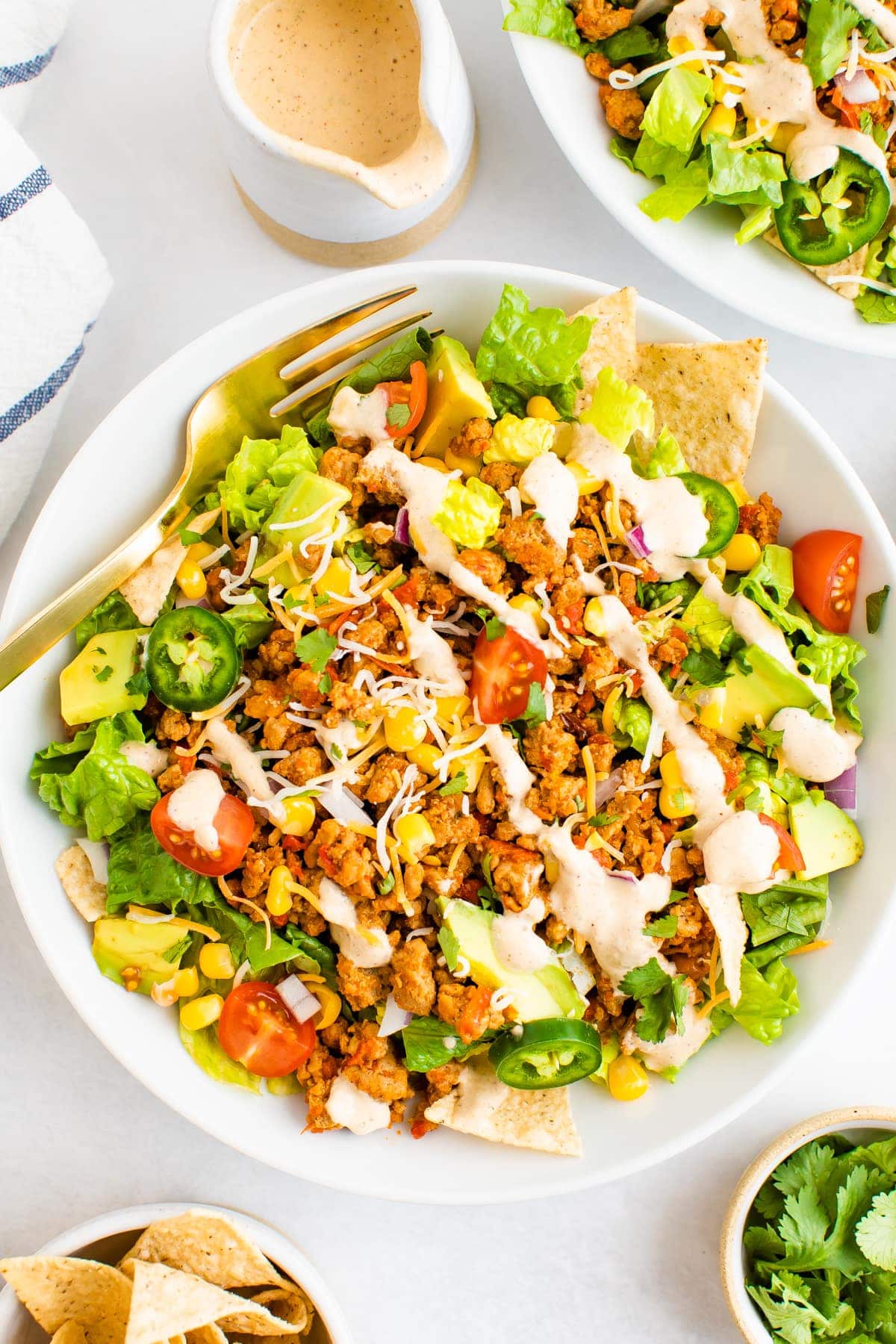 Taco salad topped with ground turkey, avocado, corn, peppers, chips and tomatoes and a southwest dressing.