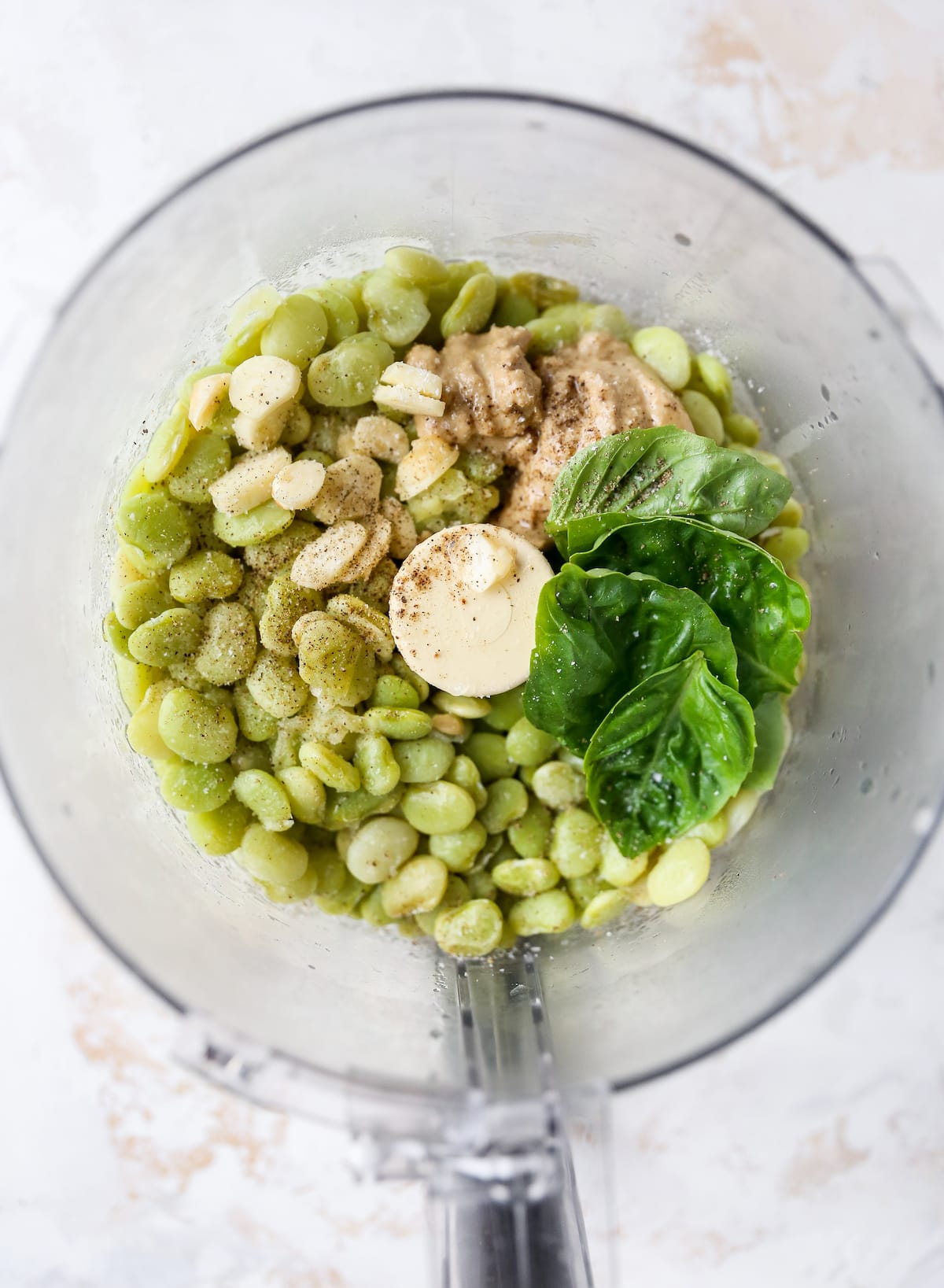 Garlic, lima beans, basil, salt and pepper in a food processor.