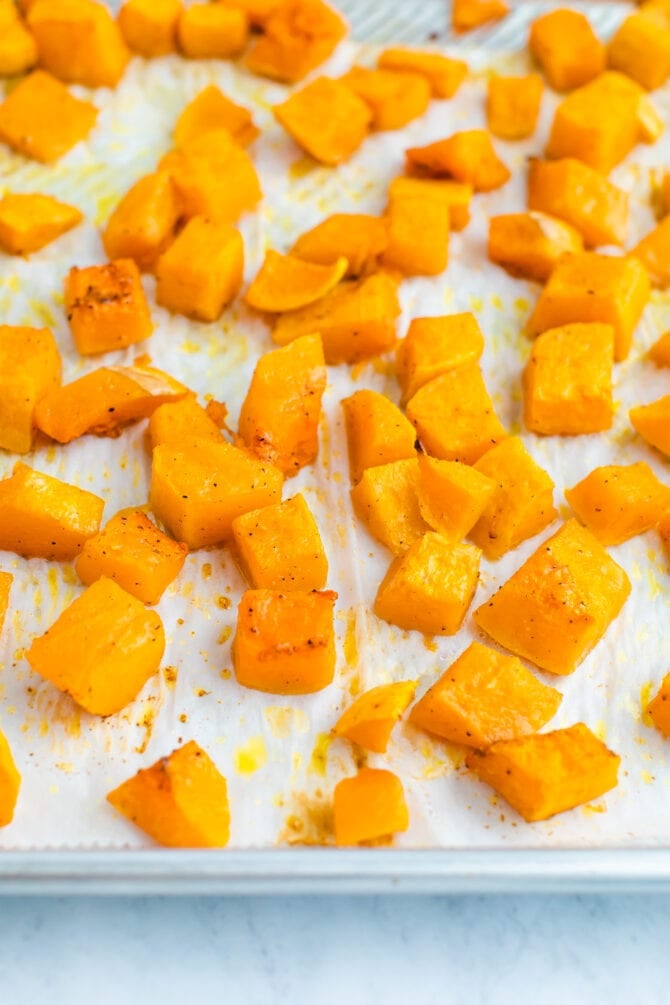 Cubes of butternut squash roasted on a sheet pan.