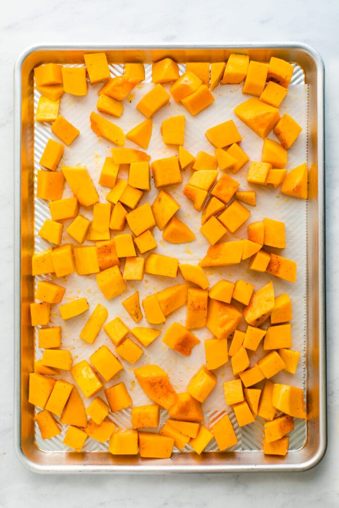 Cubes of butternut squash on a sheetpan.