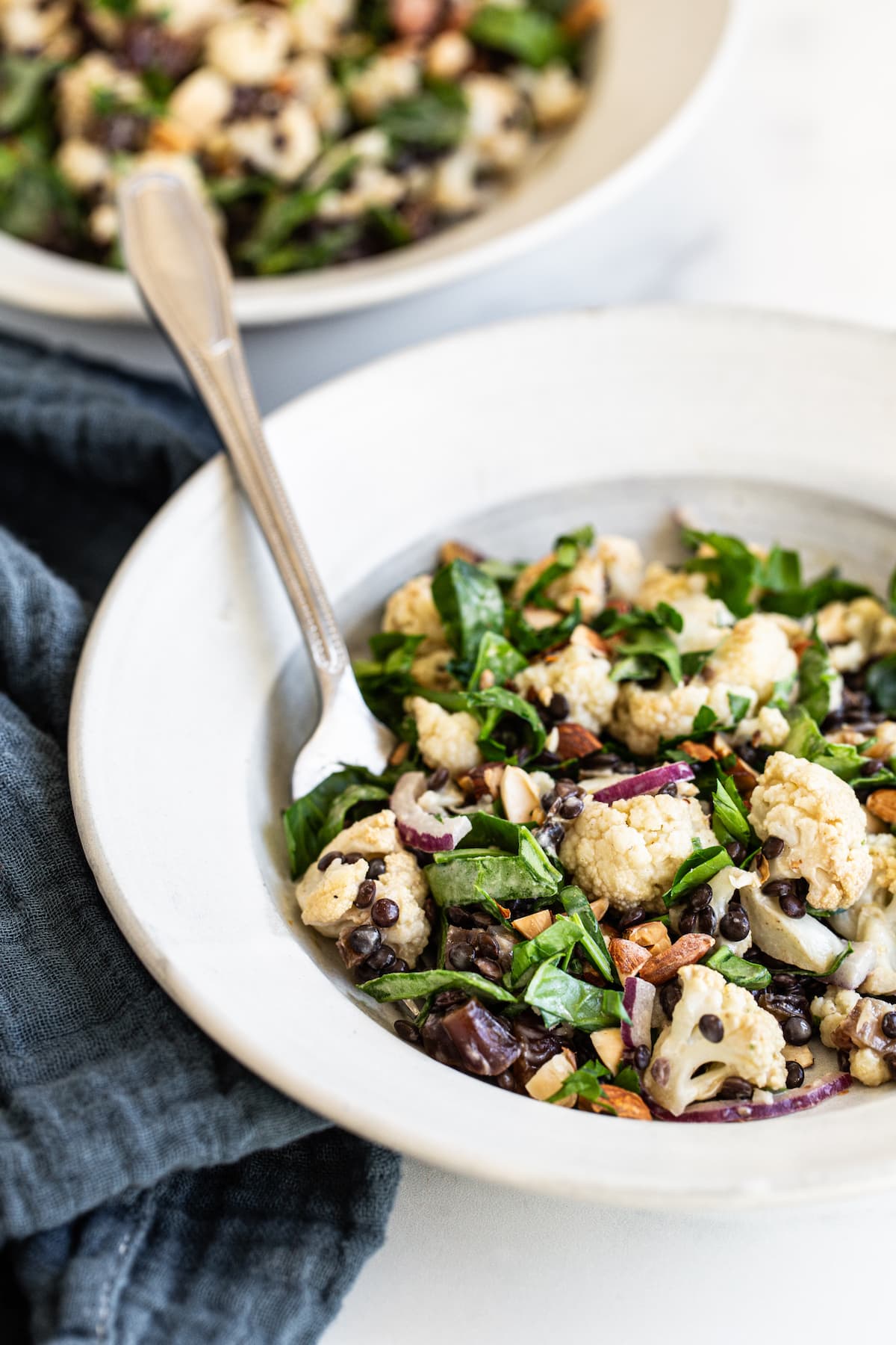 Plate with roasted cauliflower lentil salad and a fork.