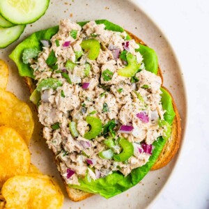 Tuna salad on an open face sandwich with lettuce.