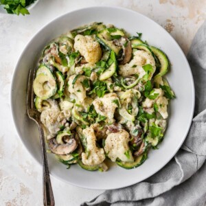 Fork on a plate of zucchini noodle alfredo.