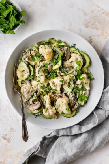 Fork on a plate of zucchini noodle alfredo.