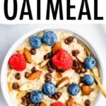Bowl of oatmeal topped with almonds, berries and chocolate chips.