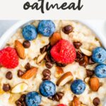 Bowl of oatmeal topped with almonds, berries and chocolate chips.