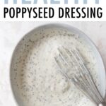 Bowl of poppyseed dressing with a whisk in it.