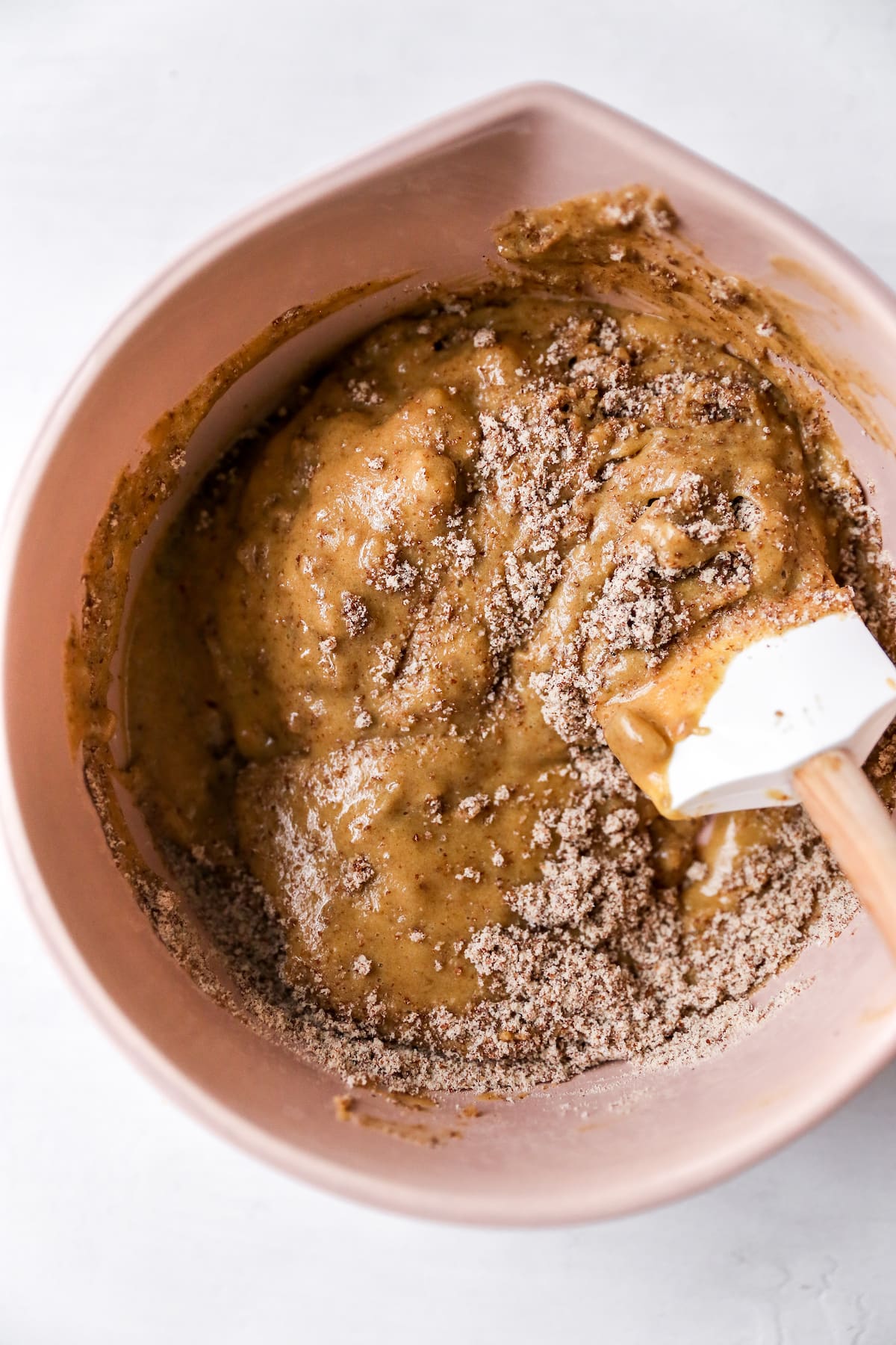 Mixing bowl with spatula stirring batter.