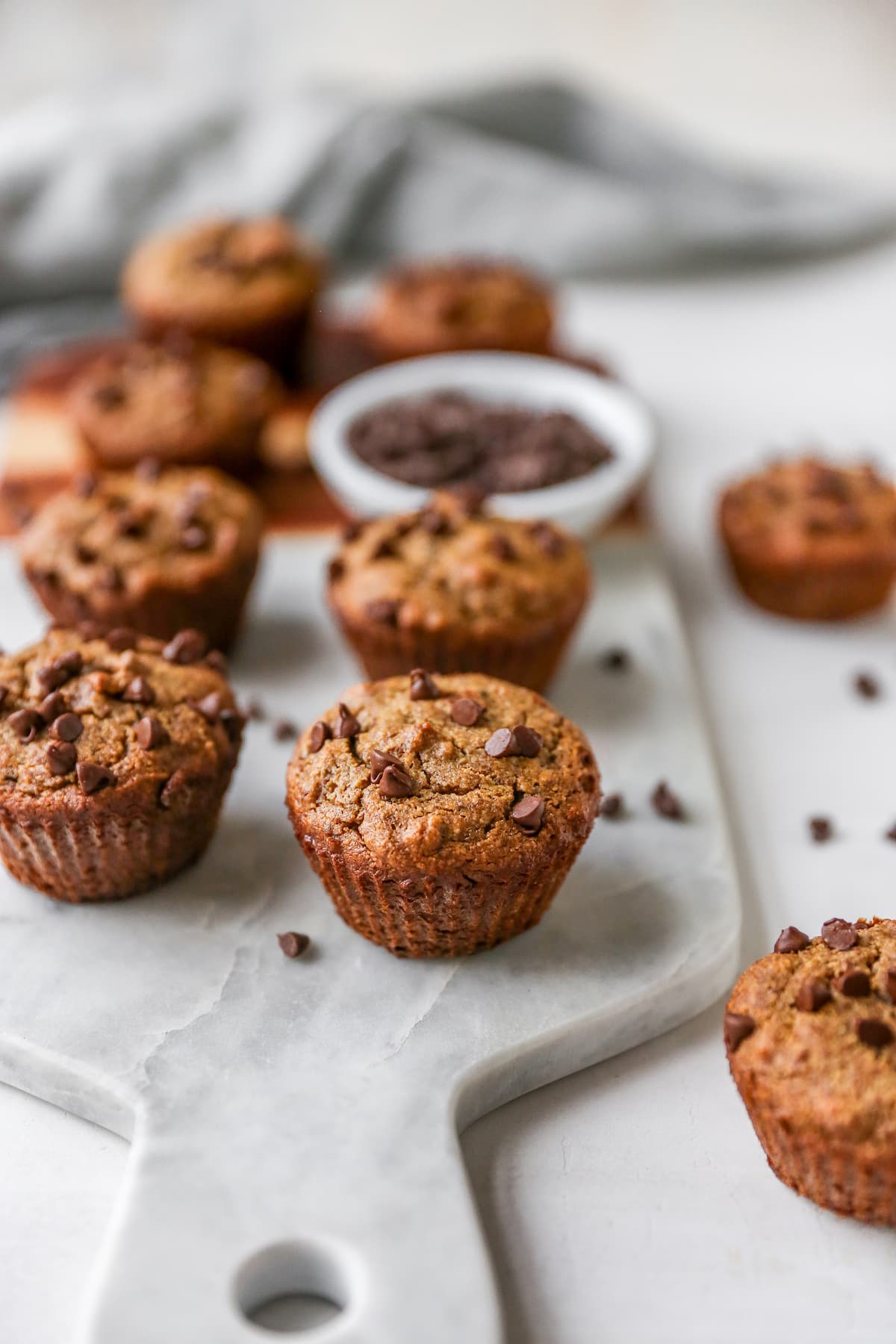 Chocolate chip almond flour muffins on a marble slab.