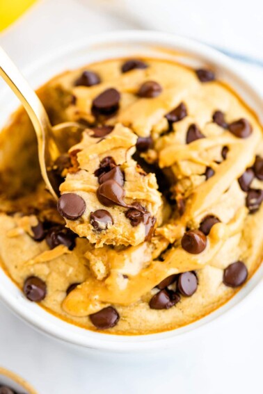 Spoon taking a bite out of chocolate chip and peanut butter topped blended baked oats.