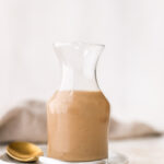 Glass jar full fo creamy balsamic salad dressing.