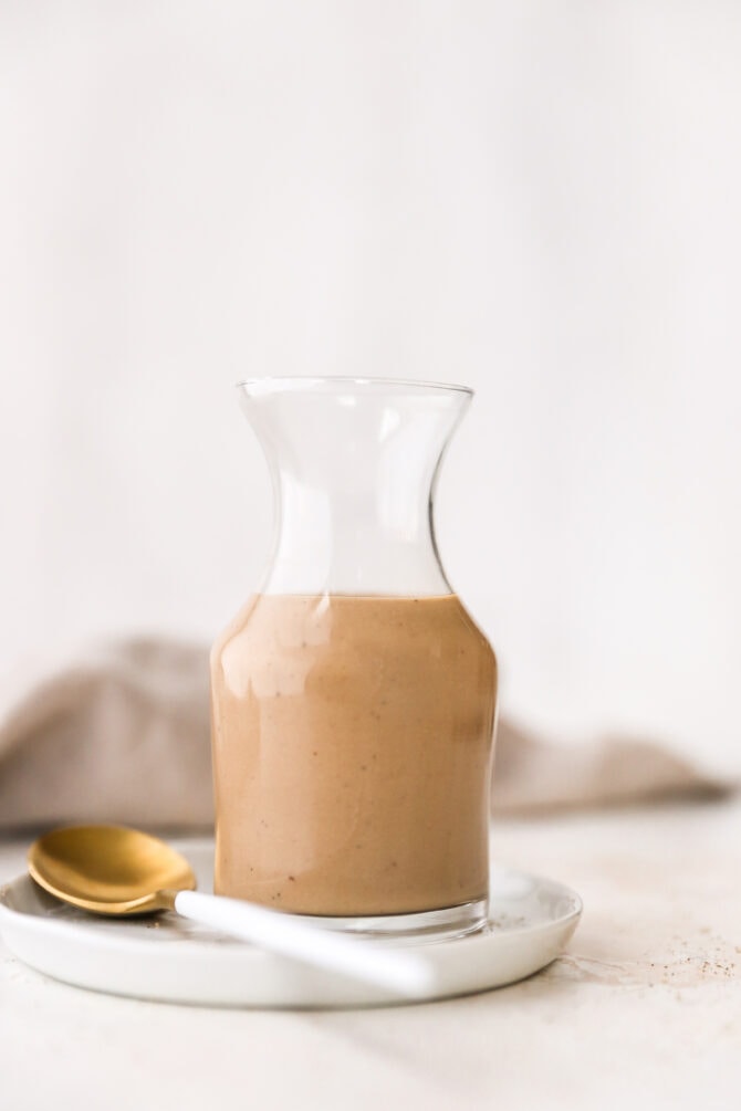 Glass jar full fo creamy balsamic salad dressing.