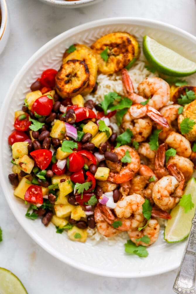 Plate with rice, pineapple salsa, jerk shrimp and plantains.