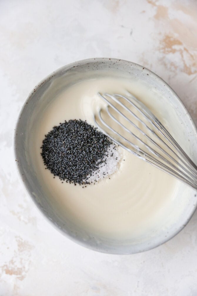 Bowl with creamy dressing and poppyseeds before being whisked together.