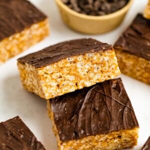 Two rice krispie treats topped with a layer of chocolate.