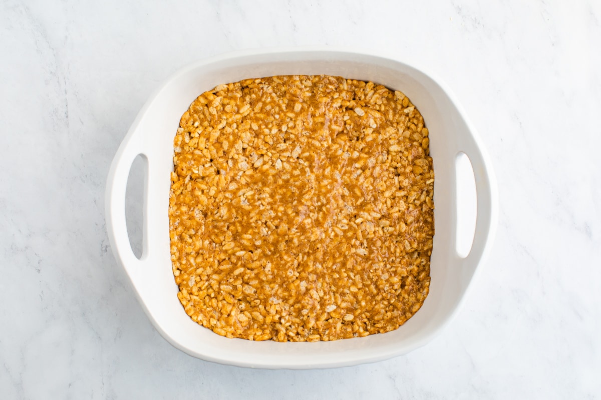 Square dish with rice krispie treat mixture in it.