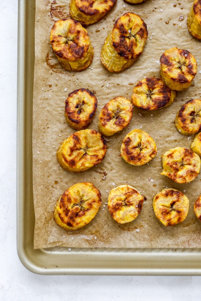 Baking sheet with browned and crispy plantain slices.