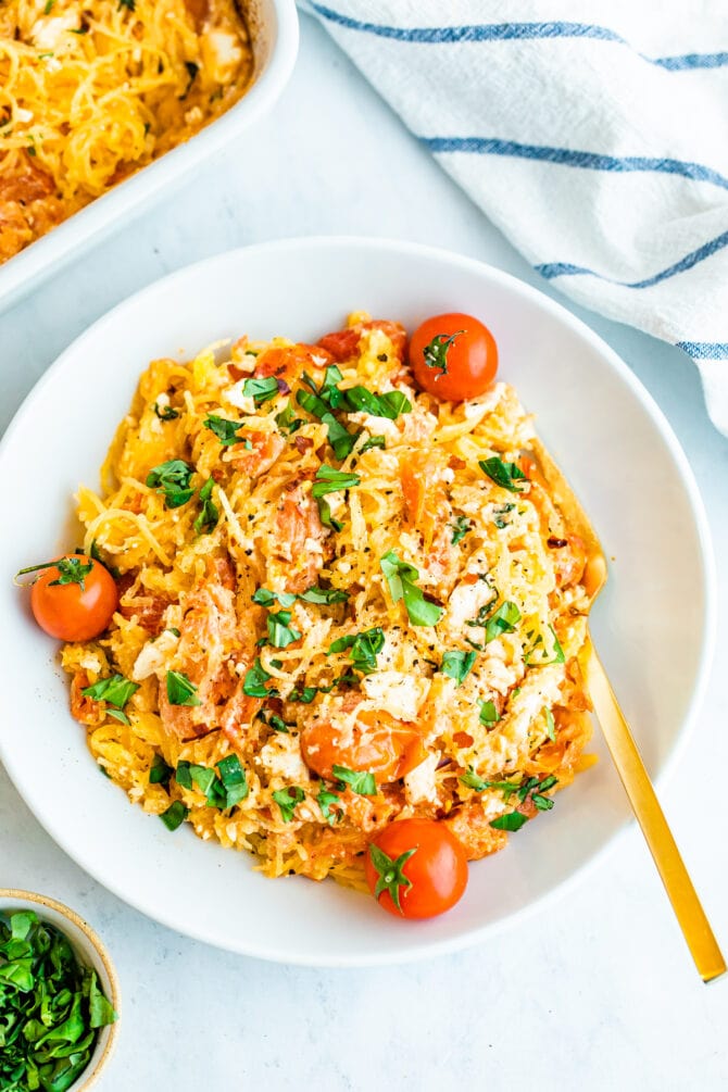 Plate of spaghetti squash with feta, basil and tomatoes.