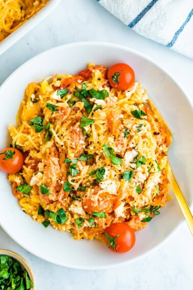 Plate of spaghetti squash with feta, basil and tomatoes.