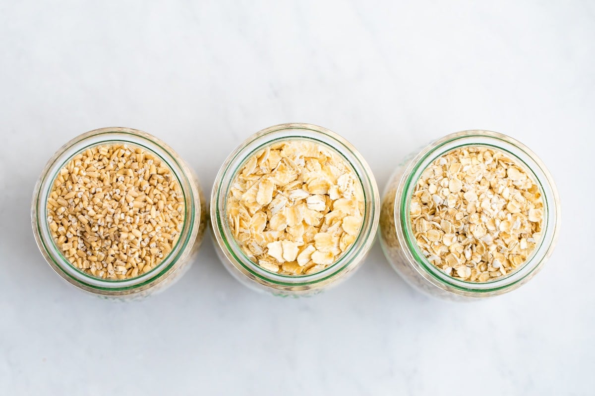 Three jars of different kinds of oats: steel cut oats, rolled oats and quick oats.