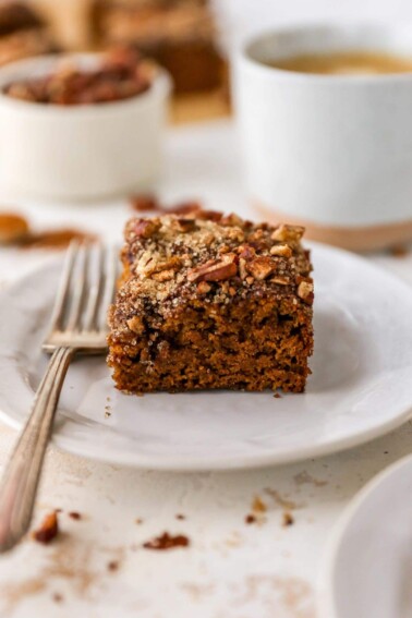Slice of coffee cake on a plate with a fork.