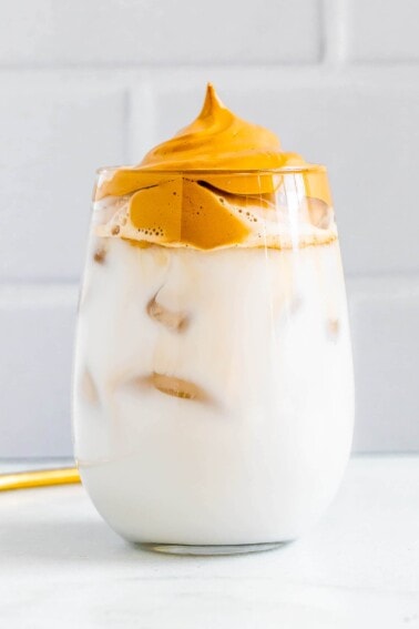 Glass with iced almond milk topped with whipped coffee.
